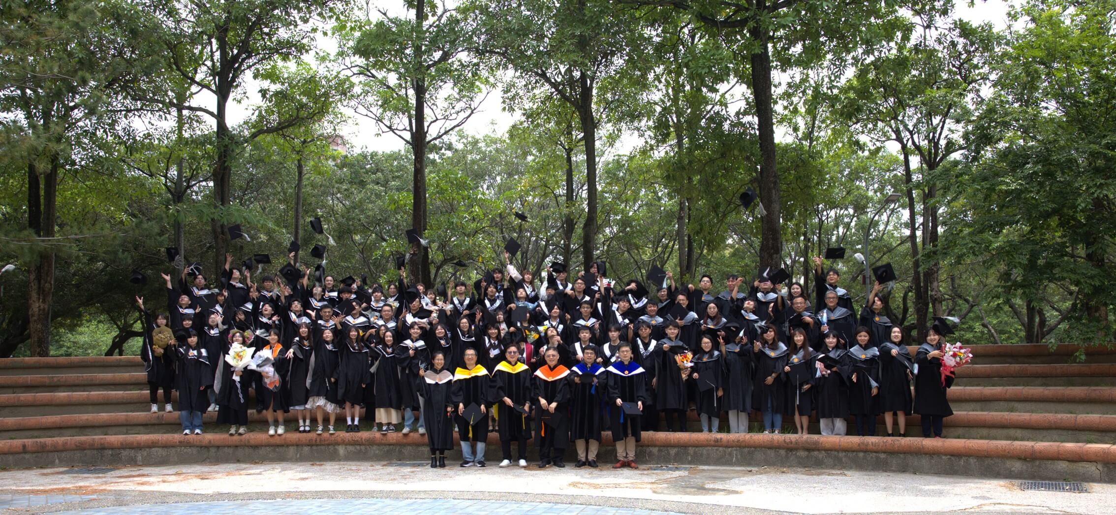畢業生在中興大學校園階梯前拋學士帽